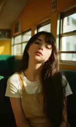 a young woman sits and looks out of a window