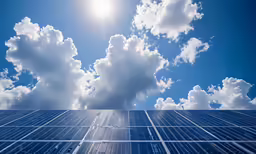 the sun shines brightly over many rows of solar panels