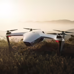 there is a white small, flying remote controlled device in the grass