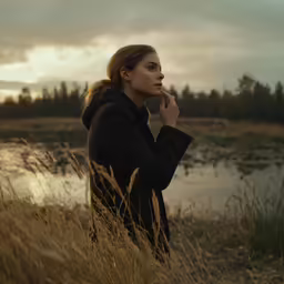a woman stands by the water in front of her