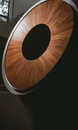 a wooden speaker is against a wall and window