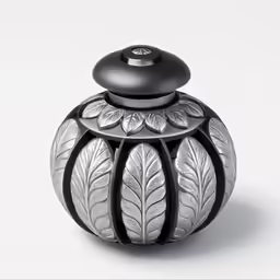 a shiny silver vase with some leaves on it