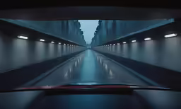 a car driving on a street near some tall buildings