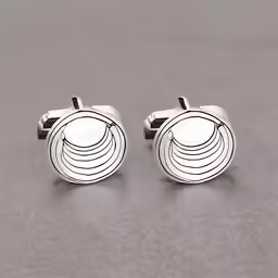 two cufflinks on a grey surface