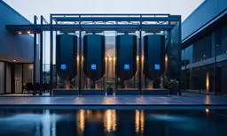an illuminated building with several tall tanks next to it