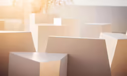 a bunch of small rectangular cubes with small trees in the background