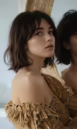 the two women are dressed in gold, one has her hair up