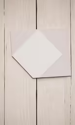 a pair of paper that are lying on wood