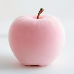a pink apple is on the ground as if in front of a white background
