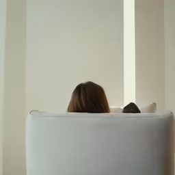a woman with brown hair laying on top of a couch