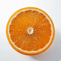 an orange cut in half on a white table