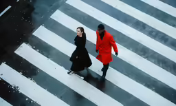 two people cross a street in the snow