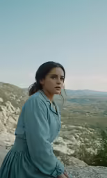 a woman standing on top of a mountain