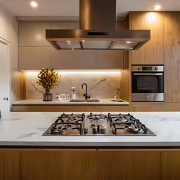 a modern kitchen with a glass hood and an electric stove top