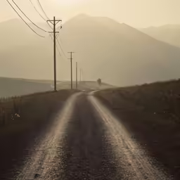 a road in the middle of a field on a hazy day
