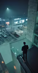 man standing on top of staircase overlooking city street at night