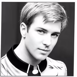 a male with a collared shirt and a necklace