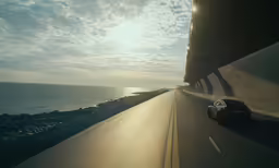 a vehicle drives down the highway by the ocean