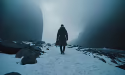 the person is walking alone through the snow