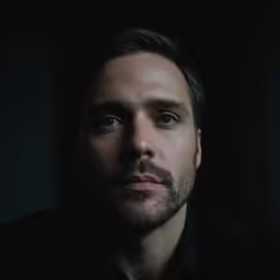 a man with a goatee stares at the camera