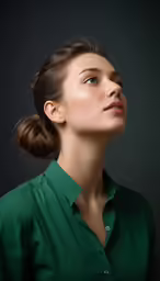a woman looking up while wearing a green shirt