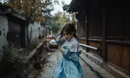 a young girl walking down the street while listening to a cellphone