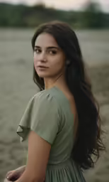 a woman in a dress looking at the camera with a smirk