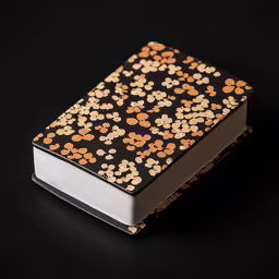 a black and yellow notebook with flowers on it