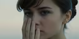 the woman is looking at something with her hands on her face