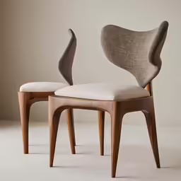 two wooden chairs with an arm shaped like a snake and a chair with a cushion, both in various shades of grey