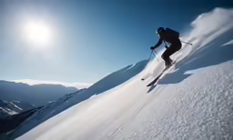 a man on skis going down the side of a snowy hill
