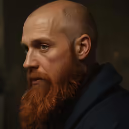 a man with a red beard stares into the distance