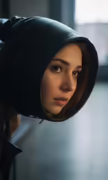 the girl with the hood up is standing