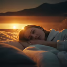 the girl lays in bed with a blanket on her shoulders as the sun sets