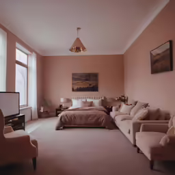 a bedroom in pink, with a sofa, chair and bed