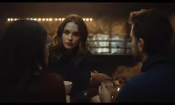 two people are talking and enjoying food together