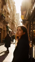 a woman standing on a sidewalk next to buildings