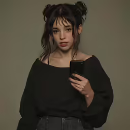 a woman with dark hair looks at her phone