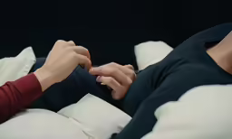 a person holds their finger on the belly of another person laying on a bed