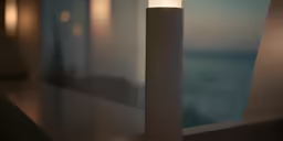 a lit candle in front of a wall
