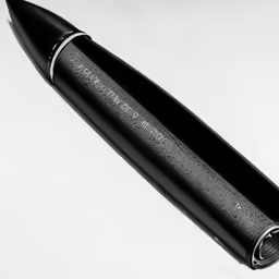 a fountain pen sitting on top of a white table