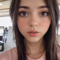a woman with long hair wearing a pink top