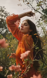 woman in orange dress standing amongst tall weeds