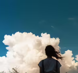 a person is standing outside while flying a kite