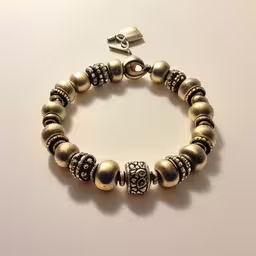 a bracelet made with bronze beads and metal beads,this is an image of a bracelet made of beaded beads