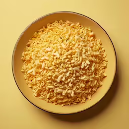 a white bowl of rice is on a yellow surface