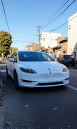 tesla tesla model 3 is white parked in the parking lot