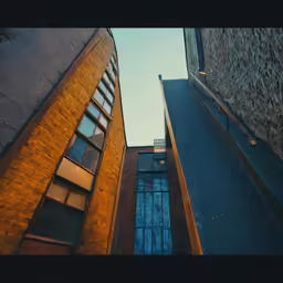 a tall brick building with two windows and one window opened