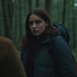a beautiful woman walking through a forest on a leash