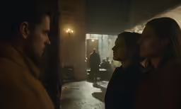 three people stand next to each other looking at each other